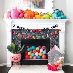 a fireplace decorated for halloween with pumpkins, balloons and pom - poms