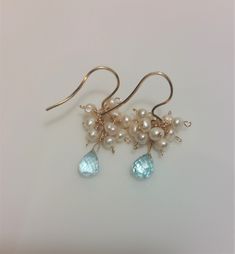 Beautiful handmade Blue Topaz and White Freshwater Pearl Earrings in 14K G Filled Wire. Lovely white freshwater seed pearls dangle above Blue Topaz Faceted Teardrop Briolettes These earrings are Perfect for day wear or an evening out. These earrings have classic lines and are perfect for day wear or a special evening out. Extremely Beautiful and Eye Catching earrings. Excellent for business casual wear, bridal parties, and as a birthday or graduation present. These Lovely Earrings are delicate i Blue Briolette Jewelry With Pearl Drop, Handmade Blue Dangle Pearl Earrings, Blue Gemstone Pearl Drop Earrings, Light Blue Topaz Drop Earrings, Blue Pearl Wedding Earrings, Fine Jewelry, Pearl Gold Earrings, Business Casual Wear, Graduation Present, Pearl Bridal Jewelry