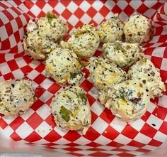 a red and white checkered paper with some food in it on top of it