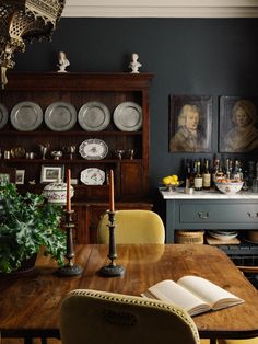 the dining room table is surrounded by plates and vases, with an open book on it