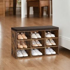 a wooden shoe rack with several pairs of shoes in it on a hard wood floor