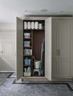 an open closet with cleaning supplies and other items on the shelves in it's center