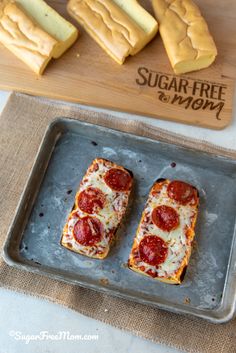 two slices of pizza sitting on top of a metal pan next to cheese and crackers