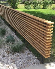 a wooden bench sitting in the middle of a garden next to gravel and plants on either side of it