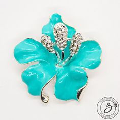 "Beautiful vibrant turquoise enameled flower brooch on silver plated metal. Popular color that matches a well known jewelry store, it's perfectly elegant and stylish. Color also referred to as turquoise, aqua blue, spa blue, teal, and seafoam green. Well made with shiny enamel and small glass stones. Set on silver plated flower, with slightly curved petals and stamens in the middle. The rhinestones in the are clear color. Very sparkly and beautiful addition to any of your projects! Add it to you Brooch Bouquet Diy, Aqua Blue Wedding, Blue Brooch, Bouquet Jewelry, Bridal Brooch, Bridal Brooch Bouquet, Brooch Dress, Blue Hibiscus, Wedding Brooch