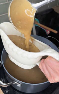 someone pouring caramel sauce into a pot on the stove