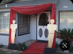 the front entrance to a house decorated with red curtains