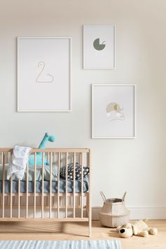 a baby's room with pictures on the wall and a crib next to it