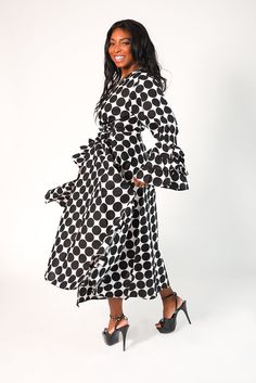 Indulge in the impeccable elegance of our 'Maria' Polka Dot Tiered Ruffle Sleeve Wrap Dress in black and white polka. Crafted from 100% wax cotton, this dress features a luxurious v-neck cut, long ruffled sleeves, and convenient side pockets. Its long floor length exudes sophistication and is available in one size ranging from medium to 2X for a perfect fit. Material: 100% Wax Cotton Care: Dry Clean Only The Model Wears A Size Medium Evening Formal, Printed Wrap Dresses, Ruffled Sleeves, Black Wrap Dress, Waxed Cotton, Dress First, African Print, Elegant Dresses, Floor Length