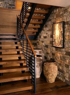 there is a stone wall and stairs in this room with wood flooring on both sides