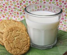 a glass of milk and a cookie on a plate