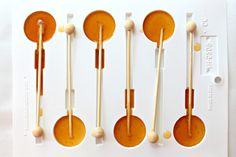 five wooden spoons are lined up in a row with chopsticks sticking out of them