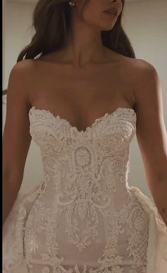 a woman in a wedding dress is standing