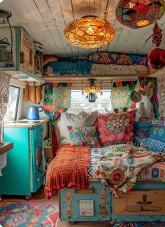 an old camper has been decorated with colorful pillows and quilts on the bed