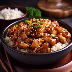 a bowl filled with chicken and rice next to chopsticks