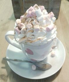 a cup filled with marshmallows on top of a white saucer