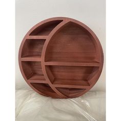 two round wooden shelves sitting on top of each other in front of a white wall