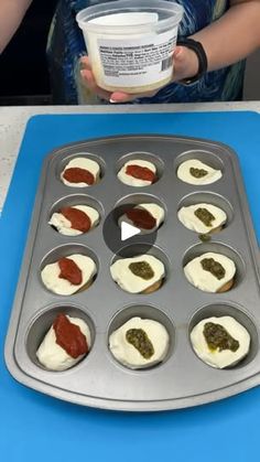 cupcakes with toppings being made in a muffin tin on a table