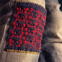 a person wearing jeans with red stitching on it