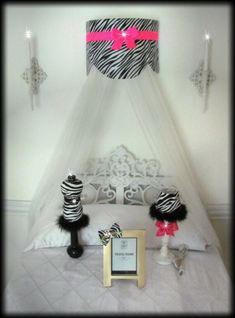 a zebra print canopy over a bed with two black and white decorations on top of it