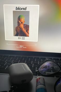 a laptop computer sitting on top of a desk next to a pair of eyeglasses