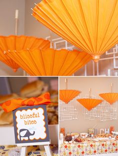 there are many orange umbrellas hanging from the ceiling and on display at this party