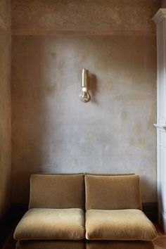 a couch sitting in front of a wall mounted light