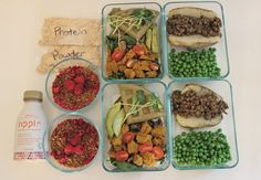 six containers filled with food sitting on top of a white table next to a bottle of water