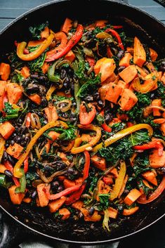 a skillet filled with vegetables and black beans