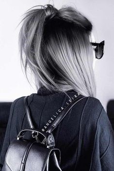 the back of a woman's head with sunglasses and a purse on her shoulder