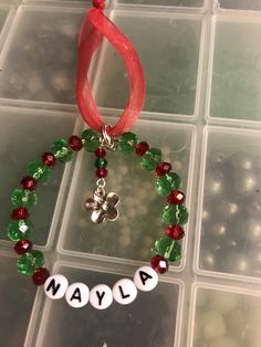 a beaded bracelet with name and shamrock charm hanging from it's red ribbon