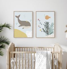 two framed pictures hang on the wall above a crib