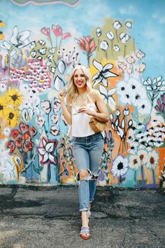 a woman standing in front of a colorful wall