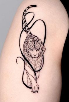 a tiger tattoo on the back of a woman's thigh, with an arrow in it