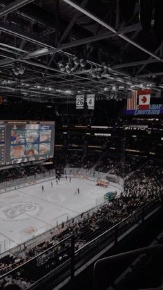 an indoor hockey rink with many fans watching the game