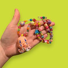 a hand holding a bunch of beads with an odd face on it