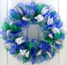 a blue and green mesh wreath on a front door with white doves in the center