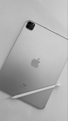 an ipad with a pen on top of it next to the back of its case