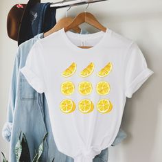 Are you looking for a lemon t-shirt for friends and family? Then this cute lemon tshirt good be a nice gift for their birthday. Surprise a lemon lover or garden lover with this unique shirt in the spring or summer. T-shirt: *This is an unisex t-shirt. Perfect fit for men and women. For women who like their t-shirt more tight than choose one size smaller. You can also choose your normal size for a little extra room to tie the t-shirt. *Measure one of your own shirts when it is laying flat. Measure just like in the picture and choose a size that comes close to your own shirt Care: *Wash in COLD water *Wash inside out *Hang out to dry *Do not iron the t-shirt How to choose the right size: *Take a t-shirt of your own that fits the way you like it. Lay it flat and measure just like in the pictu White T-shirt With Lemon Print For Summer, White T-shirt With Fruit Design For Spring, Yellow T-shirt With Lemon Print For Spring, Funny Print T-shirt For Summer Gifts, Fun Spring T-shirt As A Gift, Fun Spring T-shirt, Fun Spring T-shirt Perfect For Gifts, Spring Fun T-shirt, Spring Cotton T-shirt With Lemon Print