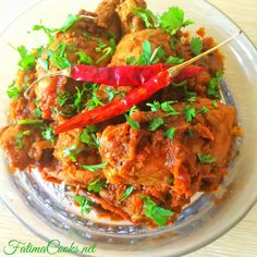 a glass bowl filled with meat covered in sauce and garnished with cilantro