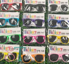 many different colored sunglasses are on display for sale at the store, some have happy birthday written on them