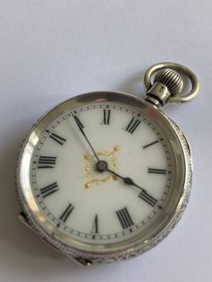 ANTIQUE Ladies Pretty Dial Solid Silver Victorian Fob Pocket Watch. Hallmarked 0.935 Continental Silver. Beautiful engraved floral & engine turned solid silver case having vacant shield cartouche to rear of case. Case. White enamel dial with black roman numerals. Guilded decoration to centre. Blue steel hands. Mechanical Swiss movement. Bow wound. Watch dimensions - 30mm diameter. Height inc. bow 45mm. This watch is sold with a 12 month guarantee from MBHI certificated watchmakers, established 1947. All watches will be serviced before shipping hence the 2-3 week dispatch. Please note - Watches are not waterproof unless otherwise stated and it is recommended not to wear them near water (i.e. washing hands, washing up, shower, swimming etc). Victorian Engraved Watch With Round Dial, Victorian Engraved Watches With Round Dial, Victorian Style Engraved Watch With Round Dial, Antique Engraved Watch Accessories, Antique Silver Pocket Watch For Anniversary, Victorian Silver Watch With Chronometer, Antique Silver Watch With Round Dial, Antique Silver Watches With Subdials, Silver Victorian Chronometer Watch