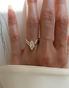 a woman's hand with a ring on it and a diamond in the middle