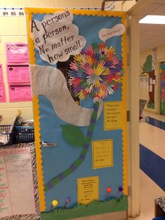 a classroom door decorated with paper flowers and writing on the front, along with other bulletin boards