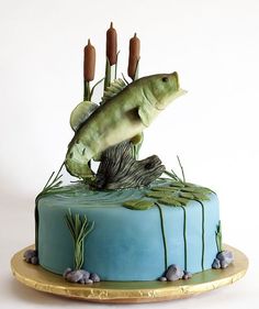 there is a cake that looks like a fish jumping out of the water with reeds on it