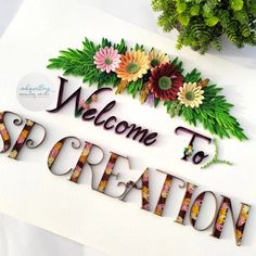 the welcome sign is decorated with flowers and leaves