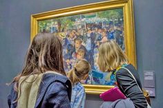 two girls looking at a painting in a museum