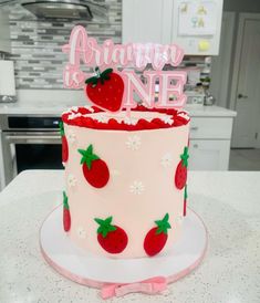 a strawberry themed birthday cake on a kitchen counter