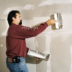 a man is painting the wall with white paint