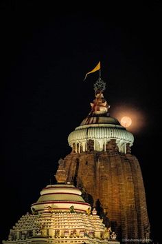 the top of an ornate building lit up at night